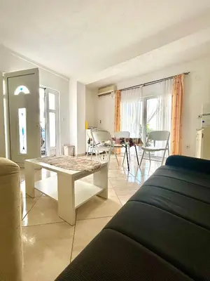 a living room with a table and a dining room at Apartmane Đekovic in Ulcinj