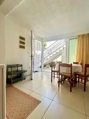 a living room with a table and chairs and a balcony at Apartmane Đekovic in Ulcinj