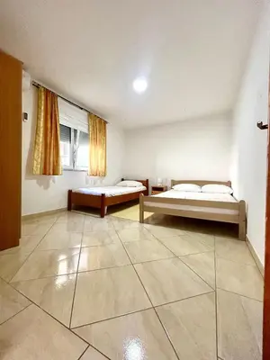 a large room with two beds and a window at Apartmane Đekovic in Ulcinj