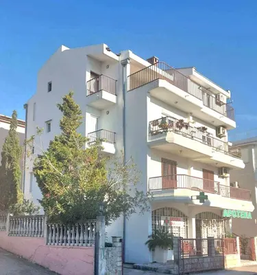 a white building with balconies on the side of it at Apartment Maruni in Bar, Susanj