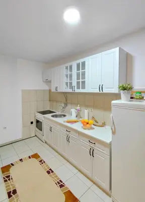 a kitchen with white cabinets and a white refrigerator at Apartment Maruni in Bar, Susanj