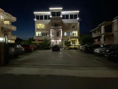 a car parked in a parking lot in front of a building at REXHEPI Apartments in Ulcinj