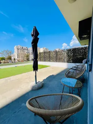 a patio with two chairs and a table and an umbrella at BAR - Jednosoban stan u centru in Bar