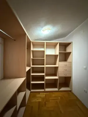 a walk in closet with white shelves and wooden floors at Vila Žuta in Bar