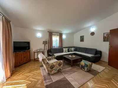 a living room with a couch and a tv at City Big Apartman in Podgorica