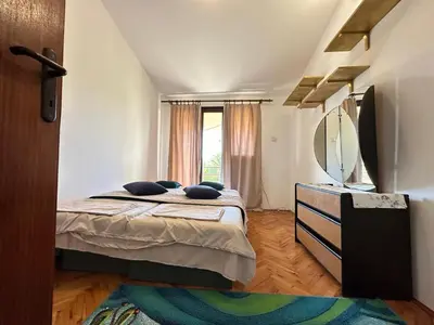 a bedroom with a bed and a large mirror at City Big Apartman in Podgorica