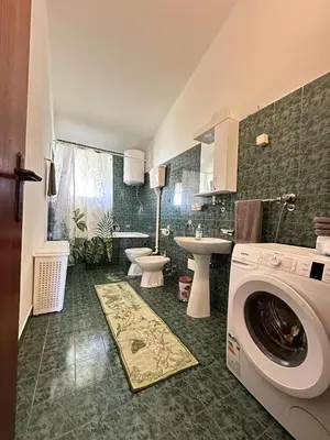 a bathroom with a washing machine and a sink at City Big Apartman in Podgorica