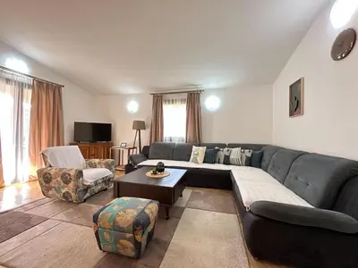 a living room with a blue couch and chairs at City Big Apartman in Podgorica