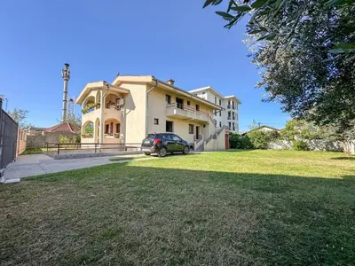 a house with a car parked in front of it at City Big Apartman in Podgorica