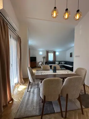 a living room with a table and chairs at City Big Apartman in Podgorica
