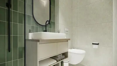 a bathroom with a sink and a toilet and a mirror at Ramonda Villa&Pool in Buljarica