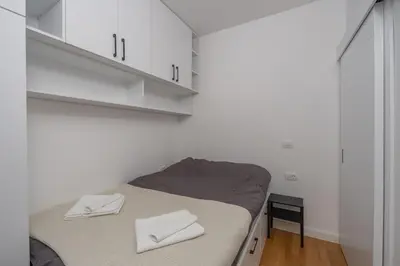 a small bed in a room with white cabinets at Deluxe Apartment Zarah in Bar