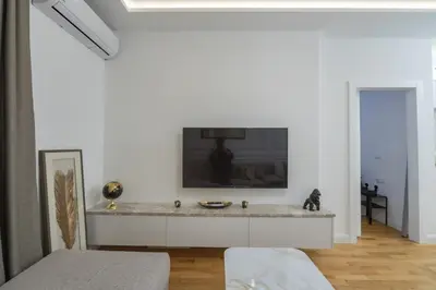 a living room with a tv on a white wall at Deluxe Apartment Zarah in Bar
