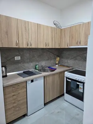 a kitchen with wooden cabinets and a sink and a stove at Zara in Bar