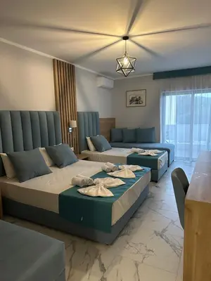 a hotel room with two beds and a couch at Hotel SPICH Biserna Obala Čanj in Čanj