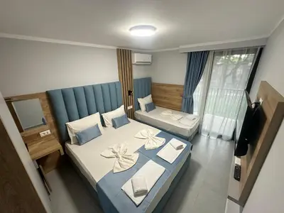a hotel room with two beds and a television at Hotel SPICH Biserna Obala Čanj in Čanj