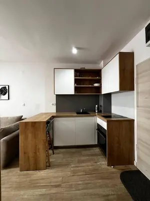 a kitchen with white cabinets and a wooden counter top at Apartment Montenegro Becici in Becici