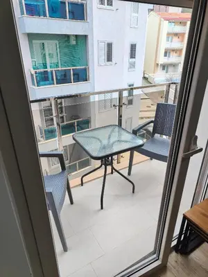 a balcony with a table and chairs and a window at Apartment Montenegro Becici in Becici