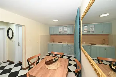 a kitchen with a table and chairs and blue cabinets at Vintage apartment in Kotor