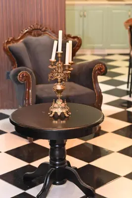 a chair and a table with candles on a checkered floor at Vintage apartment in Kotor