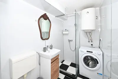 a bathroom with a sink and a washing machine at Vintage apartment in Kotor