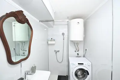 a bathroom with a washing machine and a mirror at Vintage apartment in Kotor