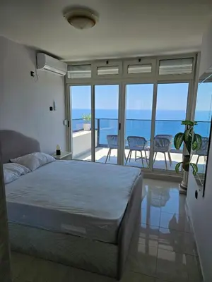 a bedroom with a bed and a view of the ocean at 50 Shades of Blue in Ulcinj