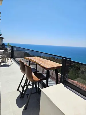 a wooden table and chairs on a balcony with the ocean at 50 Shades of Blue in Ulcinj