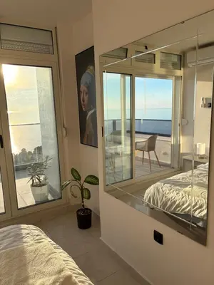 a bedroom with a mirror and a view of the ocean at 50 Shades of Blue in Ulcinj