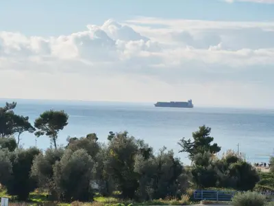 a large container ship in the water with trees at AZZURRO BAR Apartment in Bar