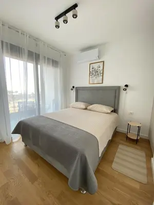 a bedroom with a large bed and a large window at AZZURRO BAR Apartment in Bar