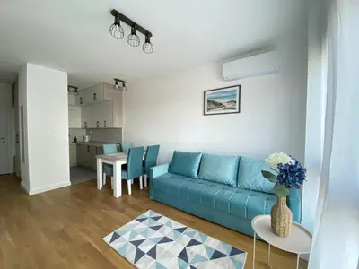 a living room with a blue couch and a table at AZZURRO BAR Apartment in Bar