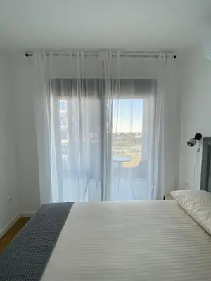 a bedroom with a white bed and a window at AZZURRO BAR Apartment in Bar