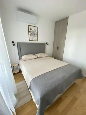 a bedroom with a large bed in a white room at AZZURRO BAR Apartment in Bar