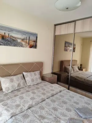 a bedroom with a bed and a large mirror at Apartman City kvart Podgorica 2 in Podgorica