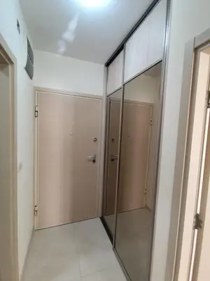 a hallway with two doors and a mirror at Apartman City kvart Podgorica 2 in Podgorica