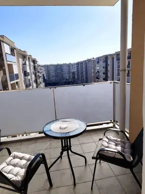 a balcony with a table and two chairs on a roof at Apartman City kvart Podgorica 2 in Podgorica