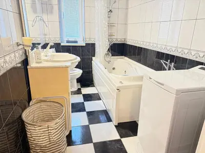 a bathroom with a toilet and a tub and a sink at Cozy central spot in Podgorica