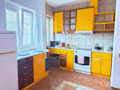 a yellow kitchen with yellow cabinets and appliances at Cozy central spot in Podgorica