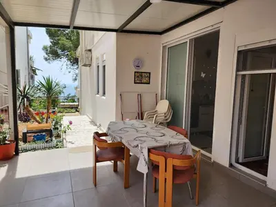 a table and chairs on a porch with a table and a patio at Inga - Apartment Ulcinj sea view in Ulcinj