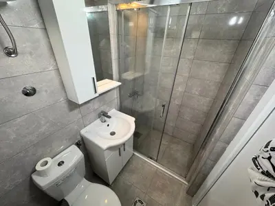 a bathroom with a shower and a toilet and a sink at Sutomore Apartman in Sutomore
