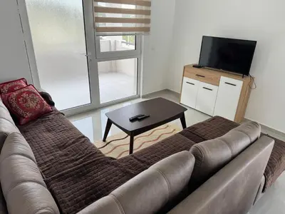 a living room with a couch and a television at Sutomore Apartman in Sutomore