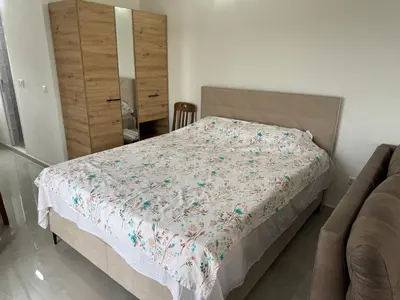 a bedroom with a bed and a dresser at Sutomore Apartman in Sutomore