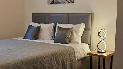 a bedroom with a bed with pillows and a lamp at 'July' Studio in Podgorica
