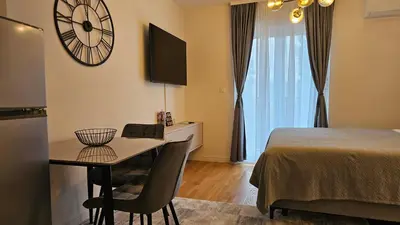 a room with a table and a clock on the wall at 'July' Studio in Podgorica