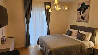a bedroom with a bed and a large window at 'July' Studio in Podgorica