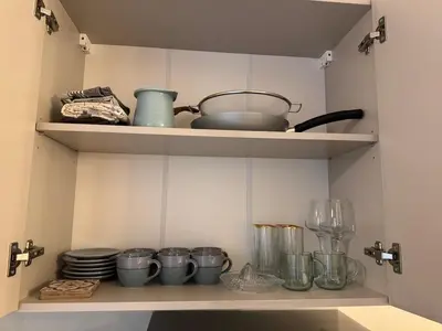a kitchen shelf with dishes and utensils on it at 'July' Studio in Podgorica