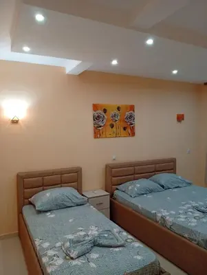 a bedroom with two beds and a painting on the wall at Grandino rooms& apartments in Ulcinj