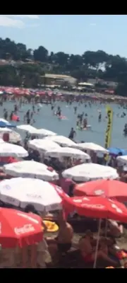 a group of umbrellas and people on a beach at Grandino holidays rooms&appart in Ulcinj