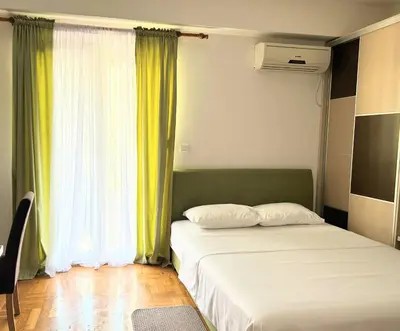 a bedroom with two beds and a window at Urban studio Blok 9 in Podgorica
